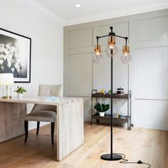 a living room filled with furniture and a lamp on top of a hard wood floor