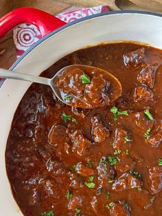 a pot full of meatballs and gravy with a spoon in it