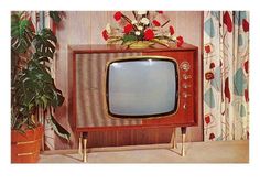 an old tv sitting on top of a wooden stand next to a potted plant