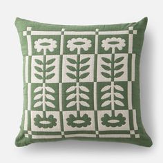 a green and white pillow with leaves on it