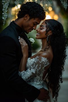 a bride and groom embracing each other under a tree