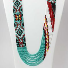 Collier de perles de verre à brins multiples avec motif de tapis Navajo et fermoir en argent sterling. Le collier est associé à des boucles d’oreilles pendantes à crochet françaises assorties.

 Longueur du collier : 30"
 Largeur du collier : 1" Navajo Rug, Zuni Jewelry, Navajo Rugs, Concho Belt, Navajo Jewelry, Clasp Necklace, Native Jewelry, Necklace And Earring Set, Pendant Rings