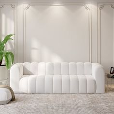 a living room with a white couch and potted plant