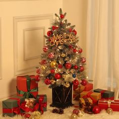 a small christmas tree surrounded by presents