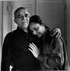 an old photo of a man and woman embracing each other in front of a door