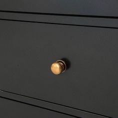 a black dresser with gold knobs and handles