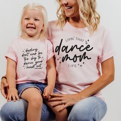 Dance mamas, we made the perfect shirt for watching your little dancer in class, dress rehearsal or a performance! Our dance mom life tee is available in pink and ash, and is soooo cute to match our dance your heart out tee for the littles! This design is also available in a match tote bag to carry around dance shoes, extra water, snacks and maybe a hairbrush for those ballet buns?? DETAILS Unisex sizing - aka mens sizing. If you want a looser fit, we recommend ordering your normal size or one up for an oversized fit. If you prefer a more fitted style, size down one. Tee - 52/48 Airlume combed and ringspun cotton/polyester. Side seams, shoulder to shoulder taping, tearaway label. Pink or Ash tee with black print Fitted Pink T-shirt With Name Print, Fitted Cotton T-shirt For Dance Class, Stretch Cotton T-shirt For Dance Class, Cotton Short Sleeve Tops For Dance Class, Pink Crew Neck T-shirt For Dance, Pink Stretch Tops For Dance, Fitted Cotton Tops For Dance Class, Casual Pink Tops For Dance, Casual Short Sleeve Dance Tops