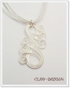 a silver necklace with the letter g on it's front and back ends in swirls