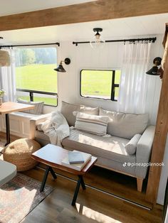 a living room filled with furniture next to a window covered in curtains and windowsills