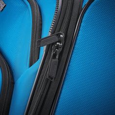 a blue suitcase with zippers on the handle is shown in close up view, it appears to be empty or unzipped