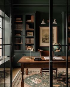 an office with dark green walls and wooden desk in front of large bookshelves