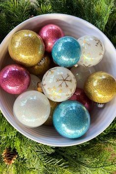 a white bowl filled with different colored ornaments