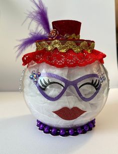 a glass ball ornament with a face painted like a clown