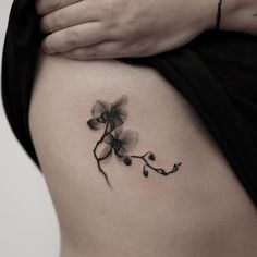 a woman's stomach with a flower tattoo on it