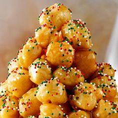 a pile of doughnuts with sprinkles on them are stacked up