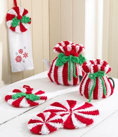 crocheted christmas decorations are displayed on a white table with red and green candy canes