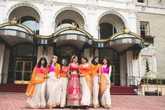 the bridesmaids are posing for a photo in front of an ornately decorated building