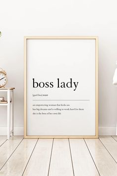 a framed poster with the words boss lady on it in front of a white wall