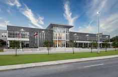 a large building with flags on the side of it and grass in front of it