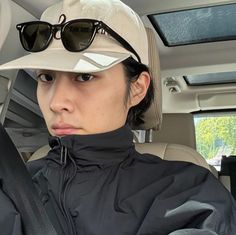 a woman sitting in the back seat of a car wearing a hat and sunglasses