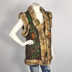 Bohemian Sleeveless Embroidered Outerwear, Sleeveless Sheepskin Vest For Fall, Fall Sheepskin Sleeveless Vest, Fitted Sleeveless Outerwear With Floral Embroidery, Sleeveless Winter Vest For Festivals, Bohemian Sleeveless Outerwear For Winter, Fitted Sleeveless Floral Embroidered Outerwear, Winter Floral Embroidered Sleeveless Vest, Brown Sleeveless Vest With Faux Fur Lining