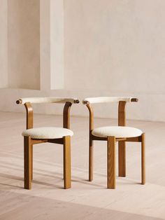 two wooden chairs sitting next to each other