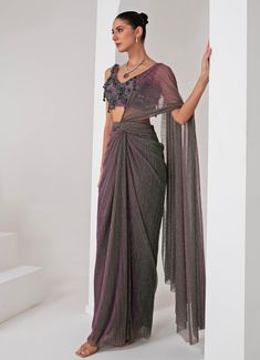 Elevate your style with the exquisite Lavender Pre Draped Crepe Saree, meticulously crafted from a luxurious platinoir crepe. The lavender saree shimmers with a subtle metallic tone, adding a touch of contemporary elegance to the traditional silhouette. Paired with a sleeveless V-neck blouse, this ensemble showcases intricate tonal crystal tassel and cutdana embellishments, creating a perfect blend of modern flair and classic grace. The pre-draped design ensures effortless wear, making it an ideal choice for those who desire both sophistication and convenience. Whether you're attending a Cocktails, Sangeet nights or a glamorous evening event, this saree promises to make a statement, reflecting your impeccable taste and style. Composition : Blouse - Crepe blend, Saree - Platinoir Crepe Care Elegant Purple Tissue Silk Pre-draped Saree, Silver Tissue Silk Traditional Pre-draped Saree, Silver Tissue Silk Pre-draped Saree, Elegant Silver Pre-draped Saree For Festive Occasion, Silver Party Wear Saree With Traditional Drape, Evening Silver Saree With Zari Work, Elegant Silver Pre-draped Saree With Unstitched Blouse, Silver Saree With Traditional Drape For Party, Silver Saree For Party With Traditional Drape