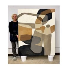 a woman standing next to a large painting