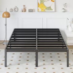 a metal bed frame sitting on top of a tiled floor next to a white wall