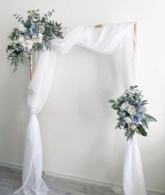 a wedding arch decorated with flowers and greenery