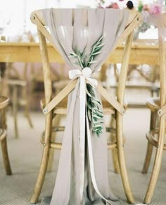 the back of a wooden chair with a white sash on it