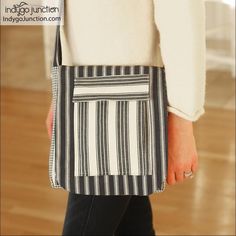 a woman carrying a black and white striped bag