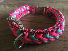 a pink, blue and green bracelet with a metal hook on it's end