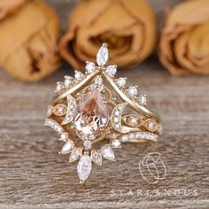 a ring with an orange stone surrounded by white and brown diamonds on top of a wooden table