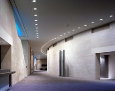 an empty hallway with lights on the ceiling