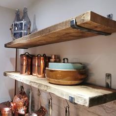 copper pots and pans are sitting on the shelf