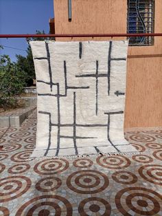 a white and brown rug sitting on top of a tiled floor next to a building