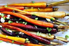 carrots and other vegetables on a plate with green onions, scallions and seasonings