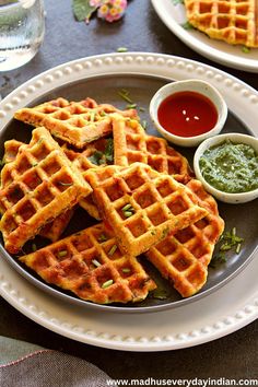 some waffles are on a plate with dipping sauce and green churnish