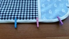 two pieces of cloth with clothes pins attached to them