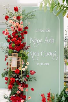 the sign is decorated with flowers and birdscage for an outdoor wedding ceremony at le ann hoi