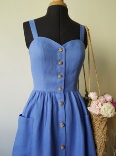 a dress on a mannequin with flowers and a basket in the foreground