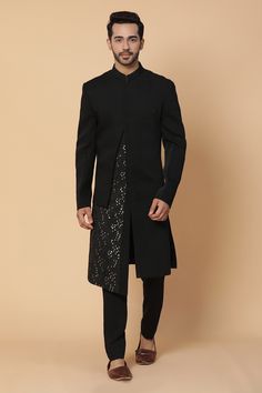 Black sherwani with overlap panels and sequins work. Paired with pant.
Components:2
Pattern:Embroidered
Type of Work:Sequins
Neckline:Band Collar
Sleeve Length:Straight Full
Fabric: Viscose, Silk
Color:Black
Other Details:
Asymmetric panels
Sequins work
Occasion:Reception - Aza Fashions Festive Semi-stitched Embellished Sherwani, Festive Embellished Semi-stitched Sherwani, Embellished Sherwani With Traditional Drape For Designer Wear, Embellished Sherwani For Designer Wear With Traditional Drape, Embellished Unstitched Sherwani For Eid, Eid Party Bandhgala Straight Kurta, Bollywood Style Embellished Sherwani With Traditional Drape, Traditional Embellished Sherwani For Festive Occasions, Embellished Sherwani For Eid Party