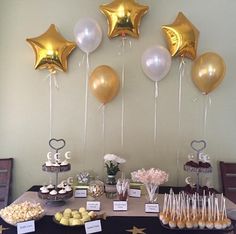 a dessert table with balloons and sweets on it