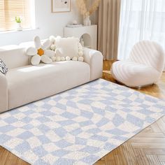 a living room with a white couch and blue rug