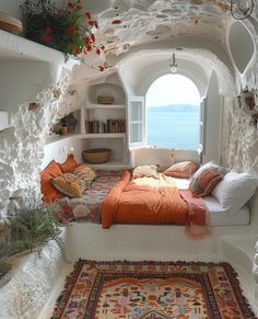 a bed sitting in the middle of a bedroom next to a window with an ocean view