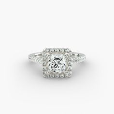 a princess cut diamond ring with pave diamonds on the shoulders and sides, set in 18k white gold