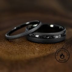 two wedding rings sitting on top of a wooden table