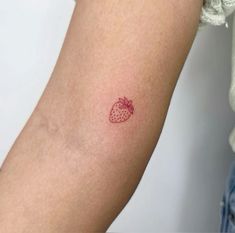 a small strawberry tattoo on the arm