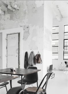 a black and white photo of a room with chairs, tables and bags on the wall